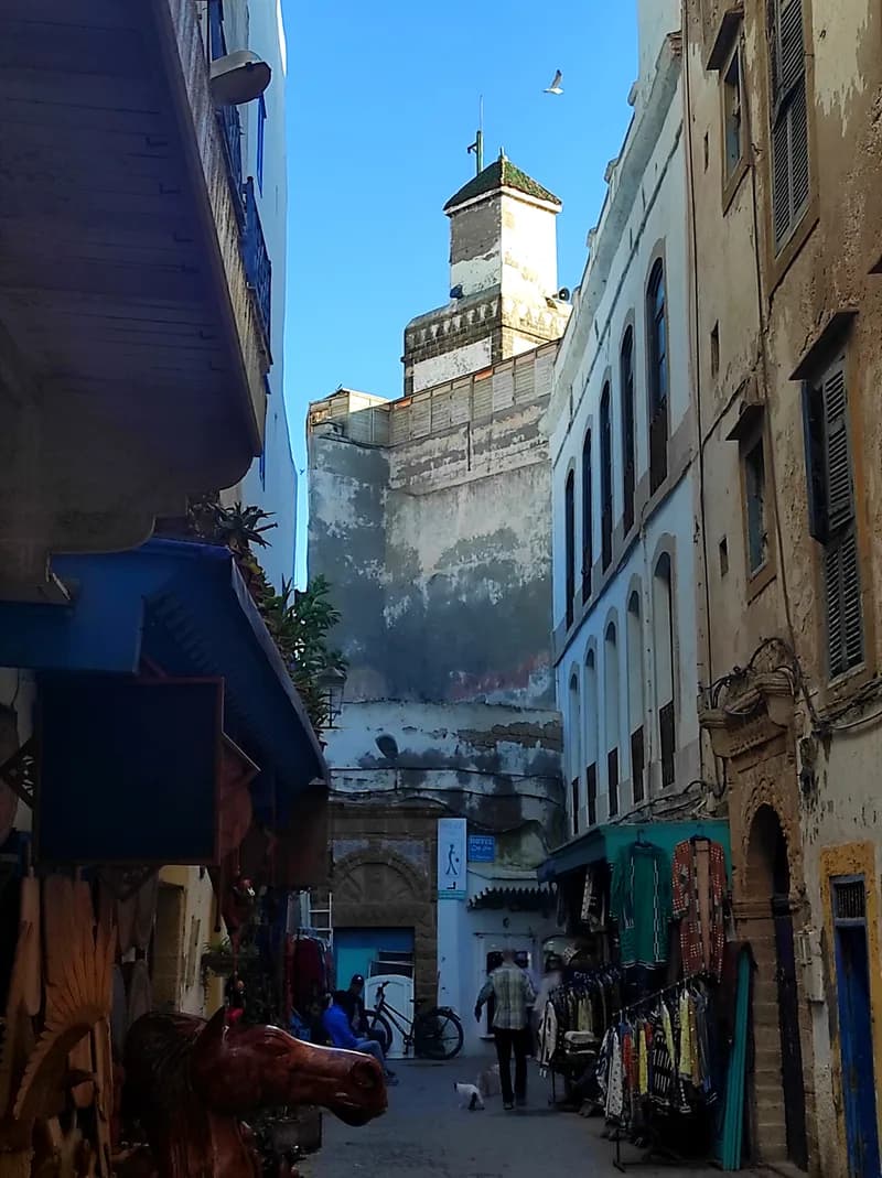Ruelle blanche et bleue de la médina d’Essaouira menant à une tour fortifiée